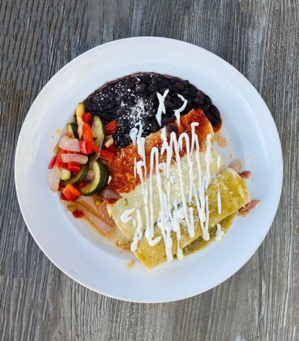 Overhead view of enchiladas, beans and vegetables